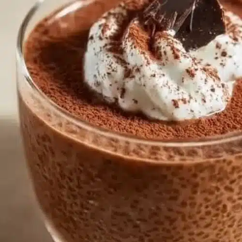 High Protein Chocolate Chia Pudding topped with whipped cream and cocoa powder
