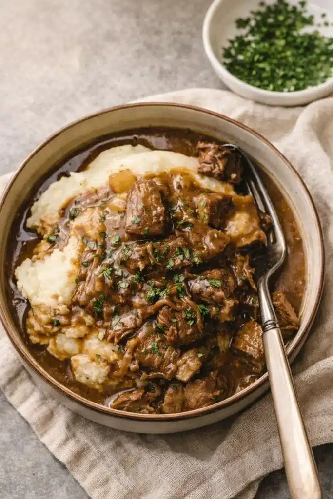 Instant Pot Beef Tips 1 Instant Pot beef tips with gravy over mashed potatoes in bowl