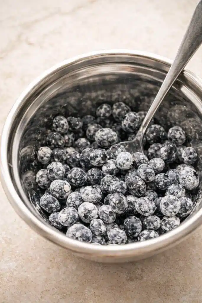 Fresh blueberries coated in flour for pancake casserole batter
