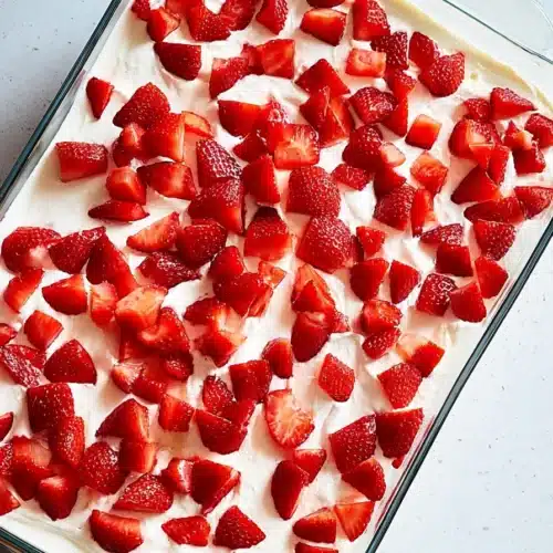 Strawberry Icebox Cake topped with fresh strawberries in a glass dish