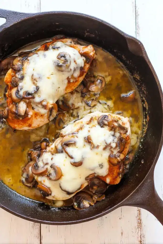 Texas Roadhouse Smothered Chicken 4 Texas Roadhouse smothered chicken with mushrooms and melted cheese in cast iron skillet