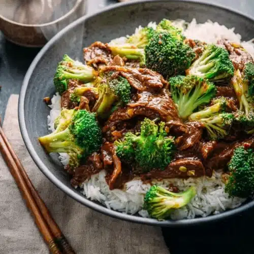 Chinese Beef and Broccoli served over rice in ceramic bowl