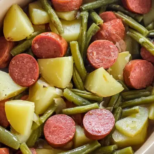 Crockpot kielbasa and green beans with potatoes in ceramic casserole dish