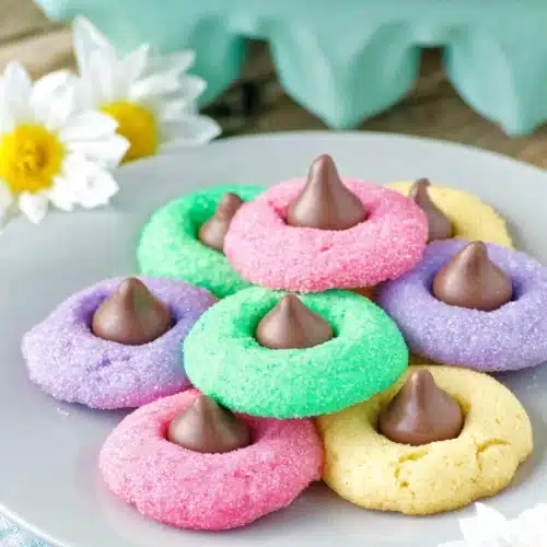Easter Blossom Cookies 3 Colorful Easter blossom cookies with chocolate kisses on white plate