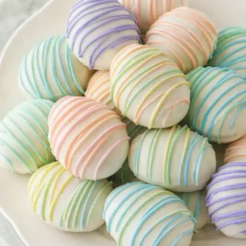 Easter Egg Oreo Cookie Balls That Are Easy and Adorable 3 Pastel Easter Egg Oreo Cookie Balls with colorful drizzle on white plate
