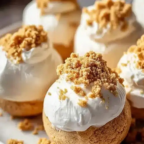 Creamy no-bake pumpkin cheesecake balls with graham crumb topping on a plate