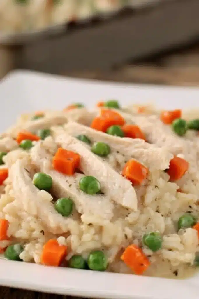 Creamy slow cooker chicken and rice with peas, carrots, and sliced chicken