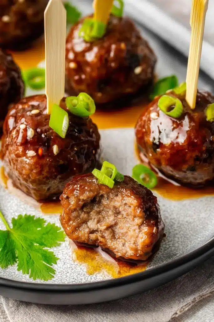 Teriyaki Meatballs Recipe That’s Quick, Juicy, and Flavorful 2 Teriyaki Meatballs cut open showing juicy interior with glaze