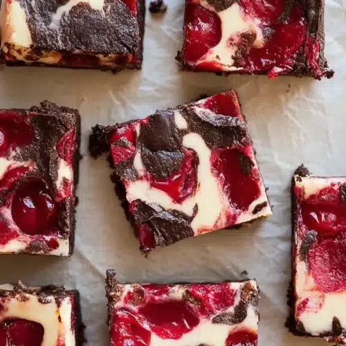 Cherry Cheesecake Brownies cut into squares with glossy cherry topping