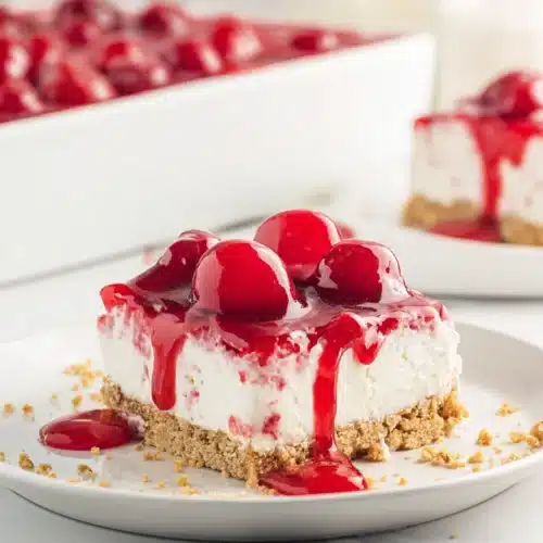 Cherry Delight Easy Creamy No Bake Dessert 5 Cherry Delight dessert slice with graham cracker crust, creamy cheesecake layer, and glossy cherry topping