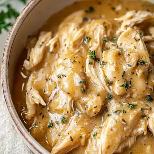 Crockpot chicken and gravy in creamy sauce with tender shredded chicken