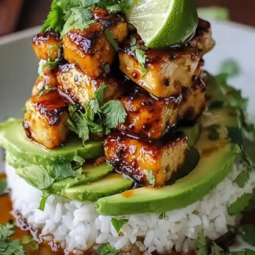 Delicious Honey Lime Chicken stack with avocado and rice on stoneware plate