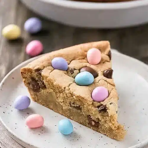 Easter Cookie Cake 3 Slice of Easter cookie cake with pastel candies on a ceramic plate