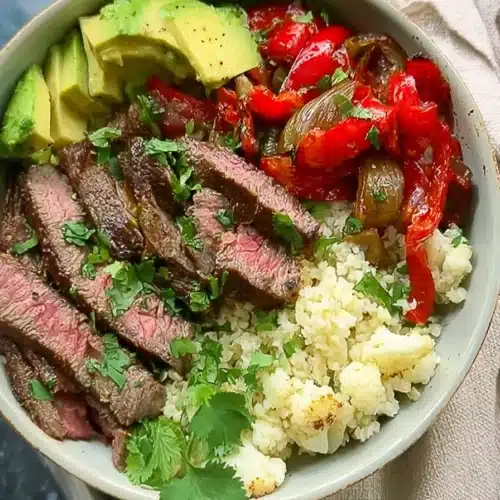High protein steak fajita bowl with avocado, peppers, onions, and cauliflower rice