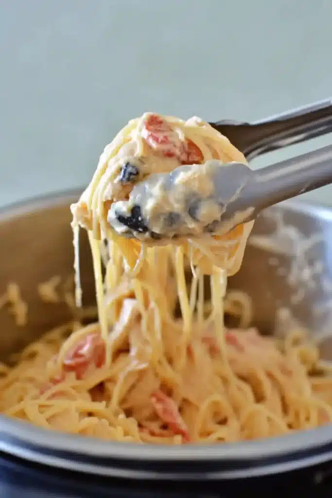 Instant Pot Chicken Spaghetti 2 Instant Pot chicken spaghetti being lifted with tongs from pot