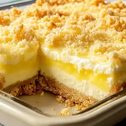 Lemon cream cheese dump cake with creamy layers and golden crumb topping in baking dish