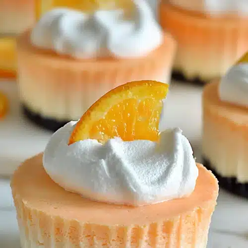 Orange Creamsicle Mini Cheesecakes: A Creamy No-Bake Citrus Treat 3 Orange creamsicle mini cheesecakes with whipped cream and fresh orange slice topping