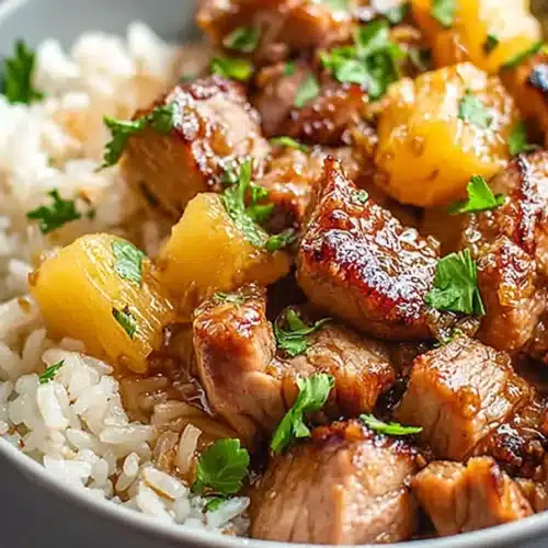 Slow Cooker Pineapple Pork 4 Slow cooker pineapple pork with rice and caramelized pineapple chunks in a white bowl