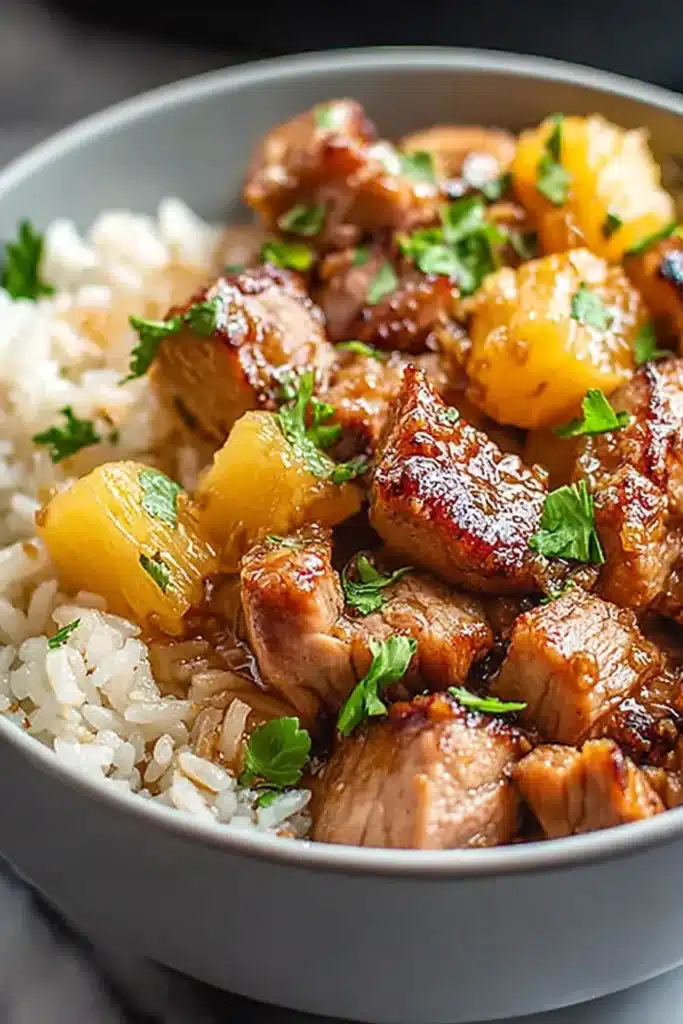 Slow Cooker Pineapple Pork 1 Slow cooker pineapple pork with rice and caramelized pineapple chunks in a white bowl