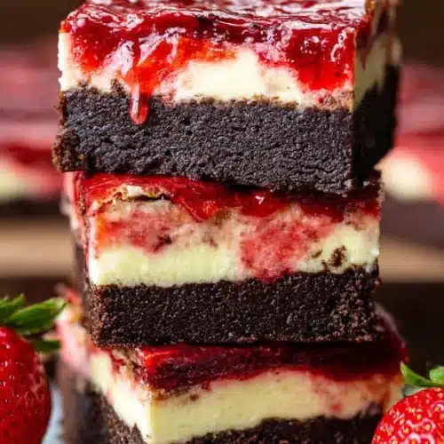Strawberry Cheesecake Brownies 4 Strawberry cheesecake brownies with chocolate base, creamy cheesecake layer, and strawberry topping