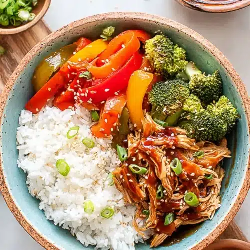 Teriyaki chicken rice bowl with broccoli, bell peppers, sesame seeds, and steamed white rice