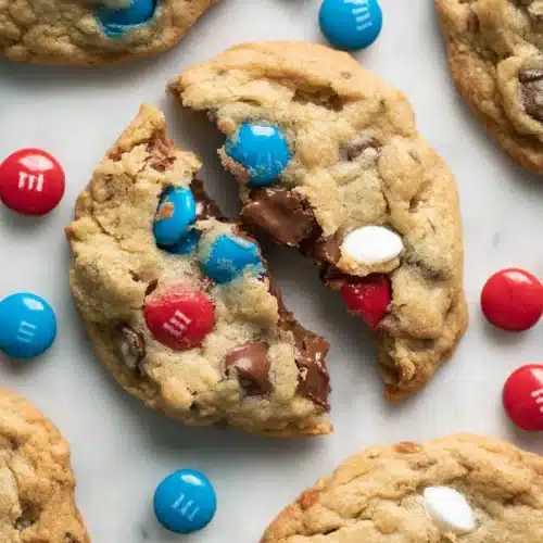 4th of July Monster Cookies broken open showing soft chewy center with chocolate and candies