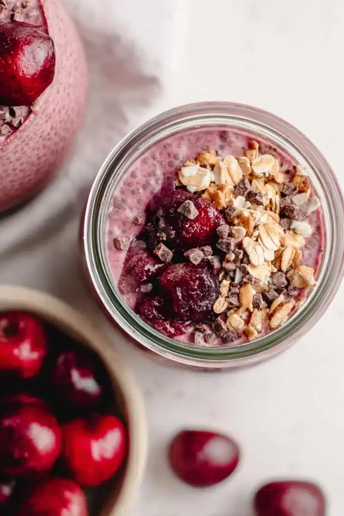 Cherry chia pudding with granola and cherries in a glass jar