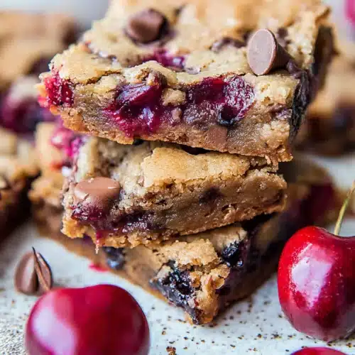 Chocolate Chip Cherry Bars Recipe Easy and Delicious Treat 4 Chocolate chip cherry bars with gooey centers and fresh cherries on a rustic surface
