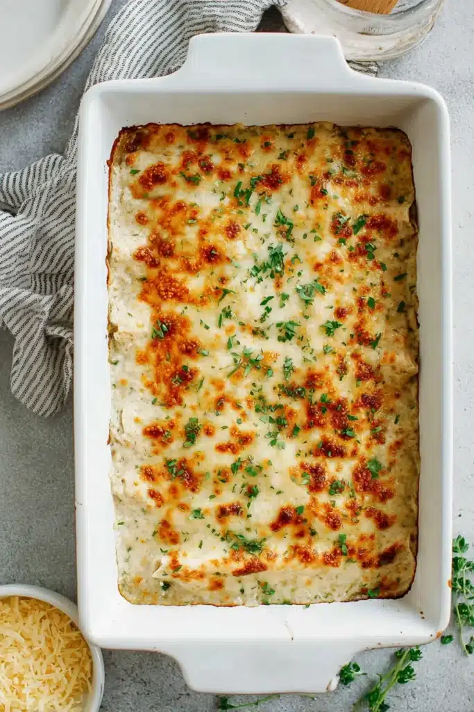 Sour Cream Chicken Enchiladas 3 Baked Sour Cream Chicken Enchiladas with golden melted cheese in dish