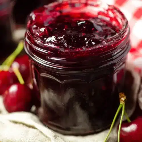 Easy Cherry Vanilla Jam Recipe You’ll Love 4 Homemade easy cherry vanilla jam in a glass jar with fresh cherries