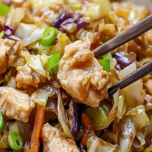 Egg roll bowl with chicken and cabbage close up with chopsticks lifting bite