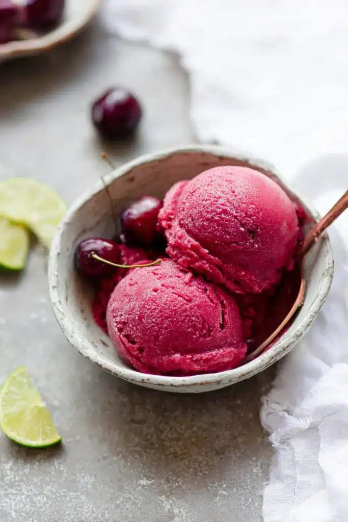 Fresh Cherry Sorbet 1 Fresh cherry sorbet scoops in a bowl with lime slice and spoon