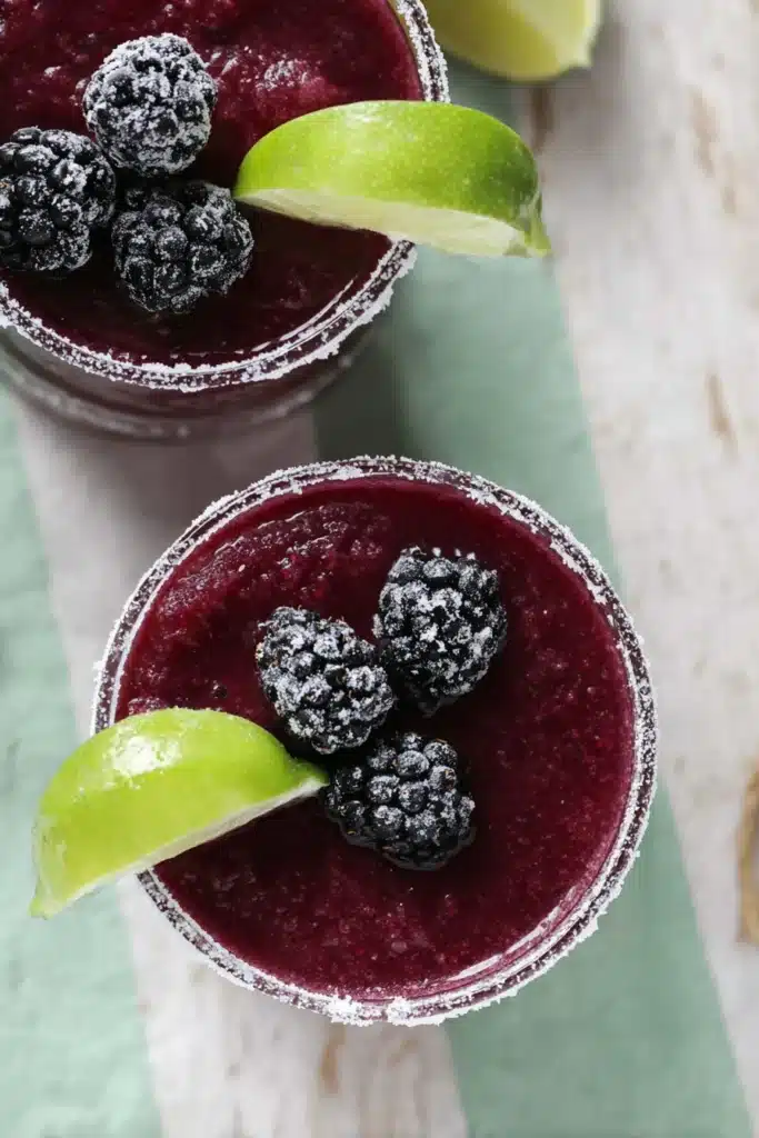 Top view of Frozen Blackberry Margarita with salted rim and lime garnish