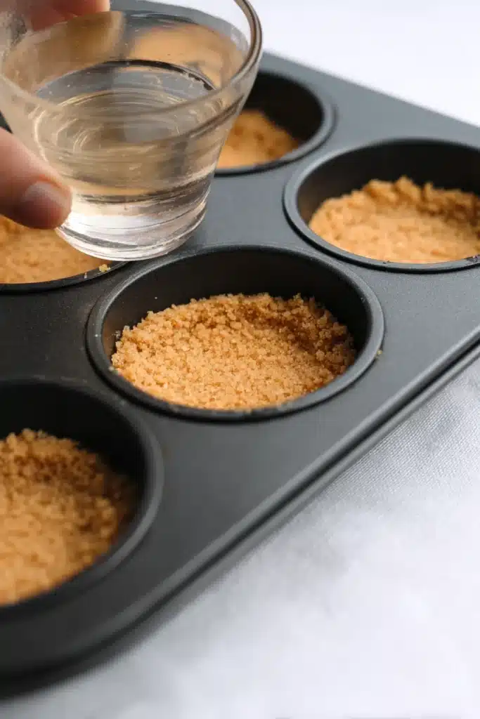 Mini Margarita Cheesecakes crust pressed into muffin tin