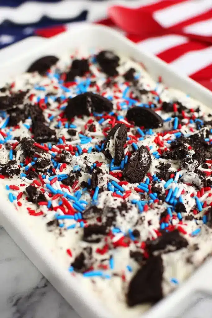 No bake Oreo cheesecake bars with sprinkles in festive red white and blue topping
