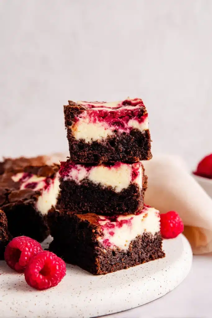 Raspberry Cheesecake Brownies 1 Stacked raspberry cheesecake brownies with creamy layers and raspberry swirl