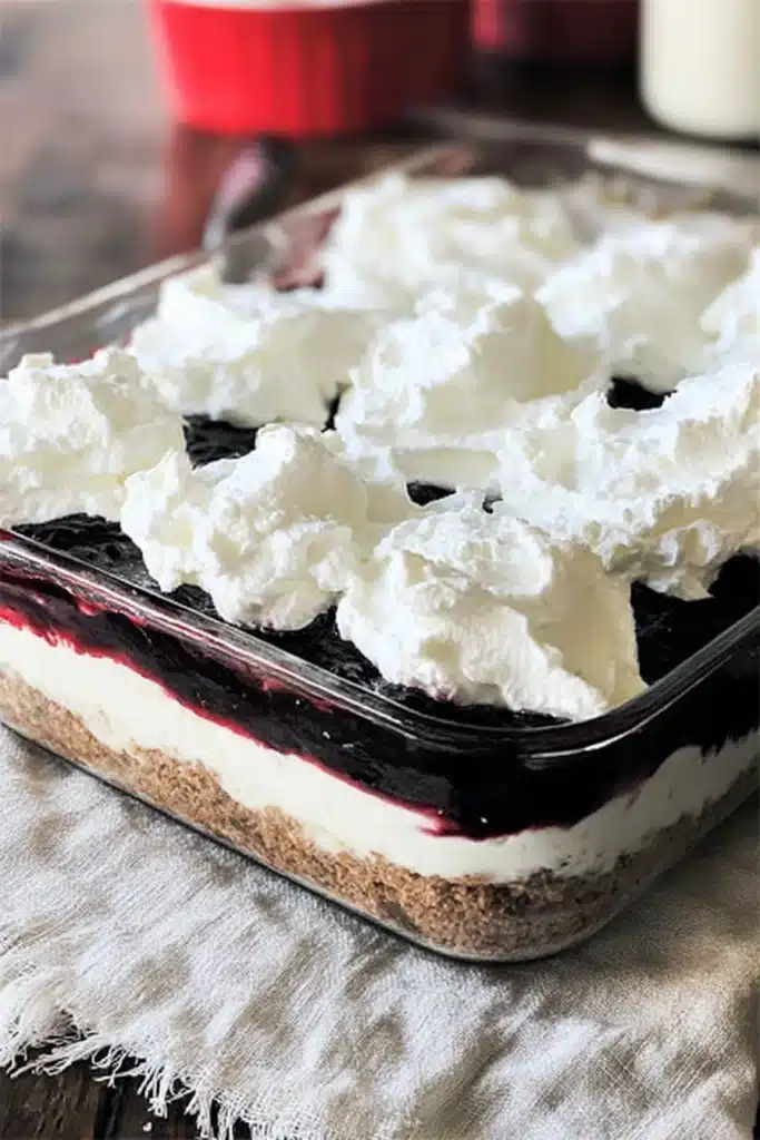This Red White & Blue Mixed Berry Yum Yum shows fluffy whipped cream over rich berry layers and a creamy base, creating a festive and delicious no bake dessert perfect for summer.