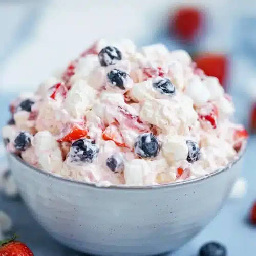 Red White and Blue Cheesecake Salad 4 Red white and blue cheesecake salad with strawberries blueberries and marshmallows in a creamy bowl