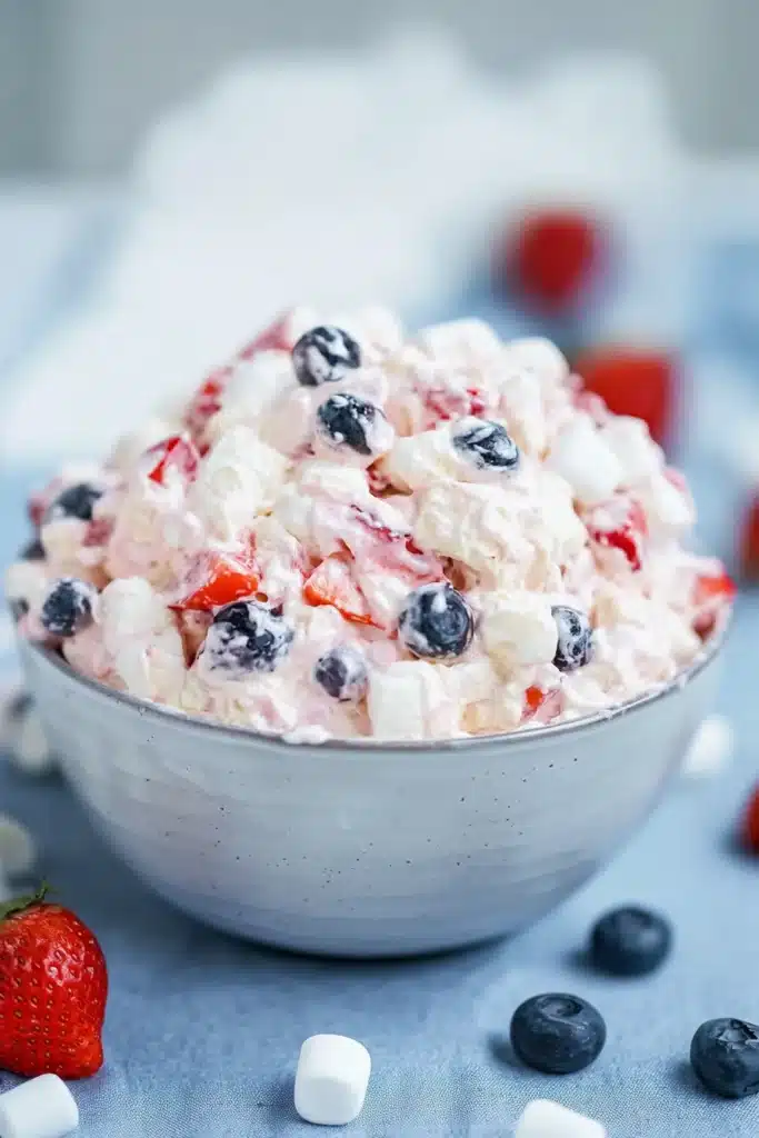 Red White and Blue Cheesecake Salad 1 Red white and blue cheesecake salad with strawberries blueberries and marshmallows in a creamy bowl