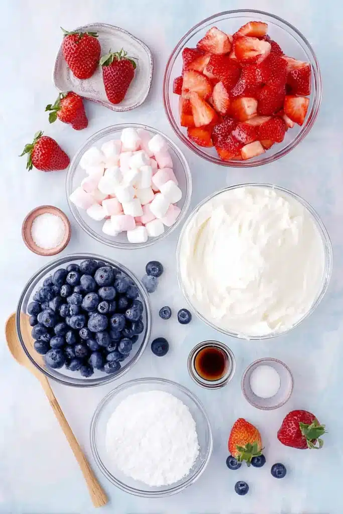 Red White and Blue Cheesecake Salad 2 Red White and Blue Cheesecake Salad ingredients with strawberries blueberries and marshmallows