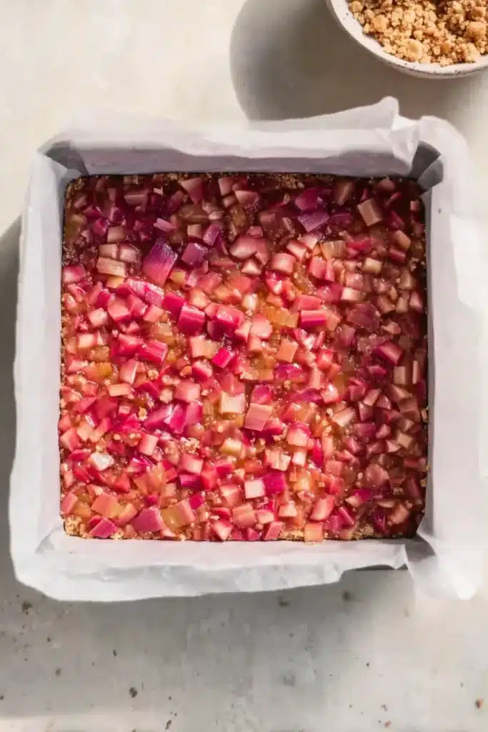 Rhubarb crumble bars filling spread in pan before baking