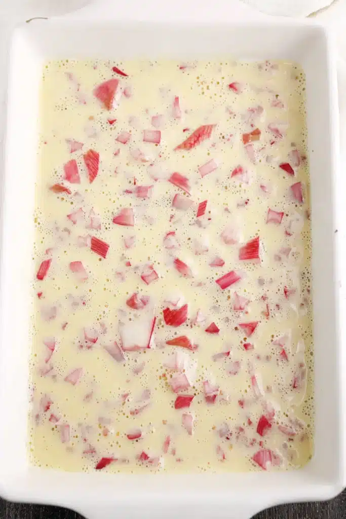 Rhubarb Dream Bars 2 Rhubarb Dream Bars filling with diced rhubarb in creamy custard before baking
