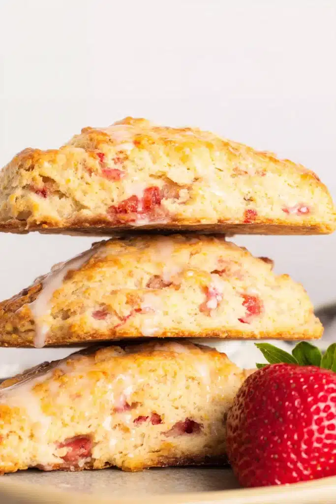Strawberry Rhubarb Scones stacked with golden crust and fresh strawberries