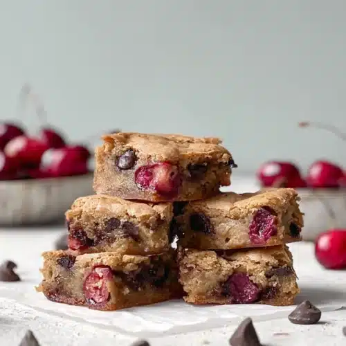 Cherry Chocolate Chip Blondies Recipe Easy and Irresistible Treat 4 cherry chocolate chip blondies stacked with juicy cherries and melted chocolate chips on light surface