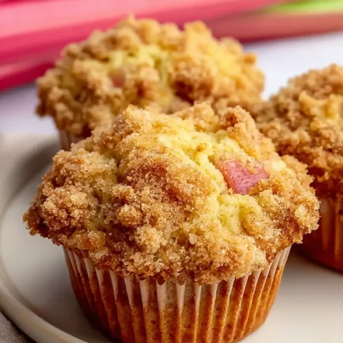 Quick Rhubarb Muffins with crumb topping on plate soft and fluffy