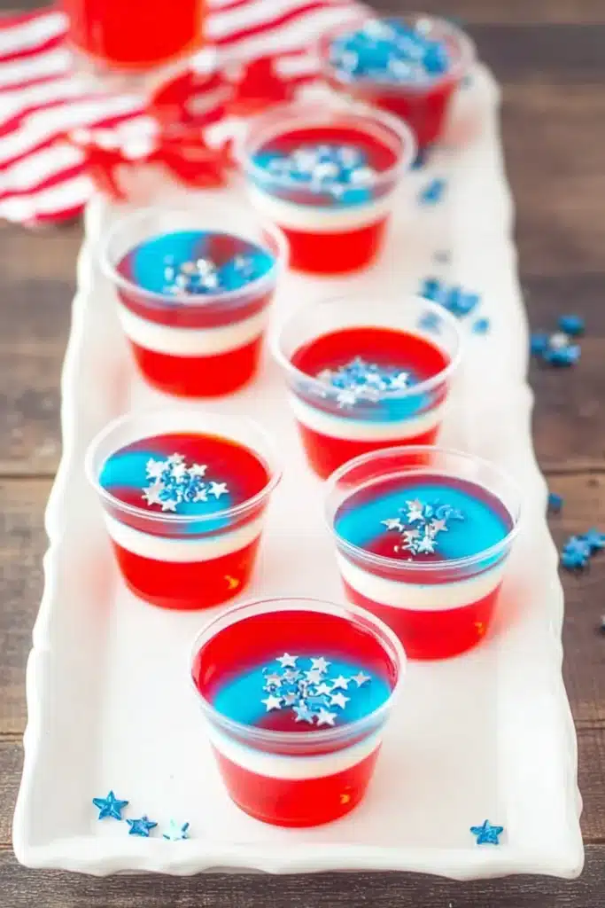 Close up of Red White & Blue Jello Shots with layered gelatin and sprinkles