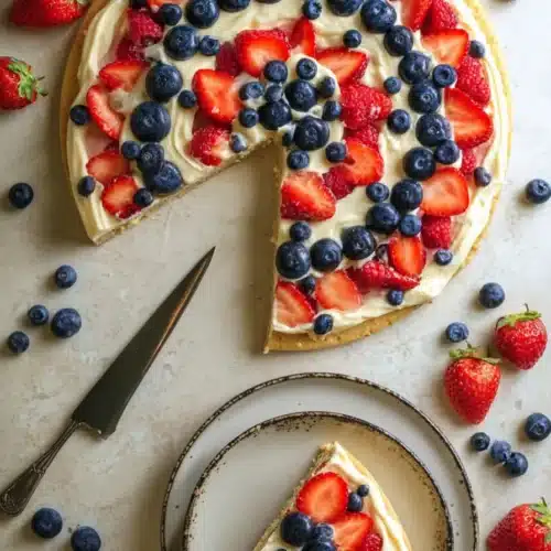 4th of July Fruit Pizza 6 4th of July fruit pizza with berries and cream cheese frosting on a cookie crust