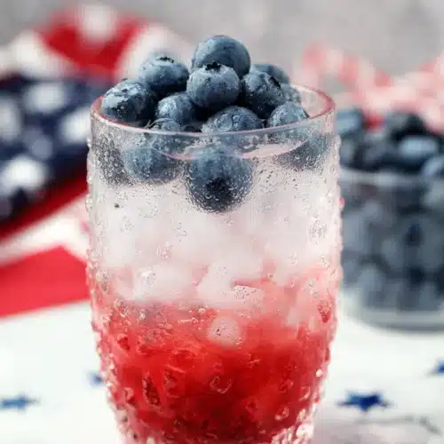 4th Of July Mojito with blueberries and raspberry layers in a festive cocktail glass