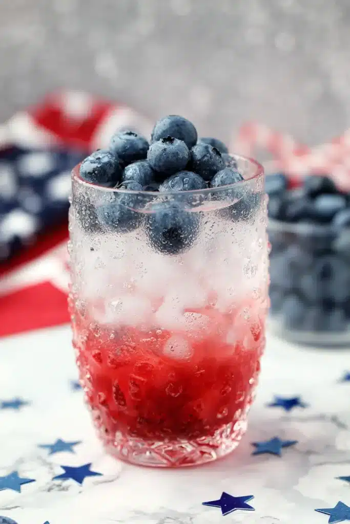 4th Of July Mojito with blueberries and raspberry layers in a festive cocktail glass