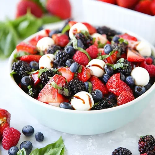 Berry Caprese Salad with fresh berries, mozzarella pearls, basil, and balsamic glaze
